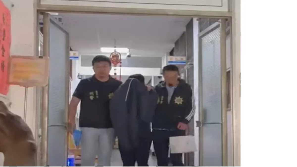 ▲黃男以外套掩蓋頭部，低頭拒絕回答媒體問題。（圖／翻攝畫面）