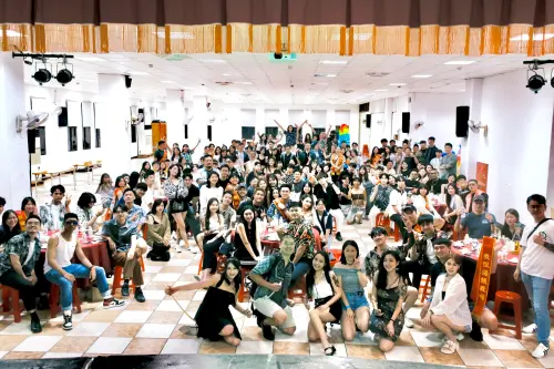 ▲紅桌、塑膠椅與紅布條，搭配花襯衫與氣球拱門，勾勒出台味辦桌辦桌氛圍，吸引近 200 人齊聚。（圖／章哲榮攝）