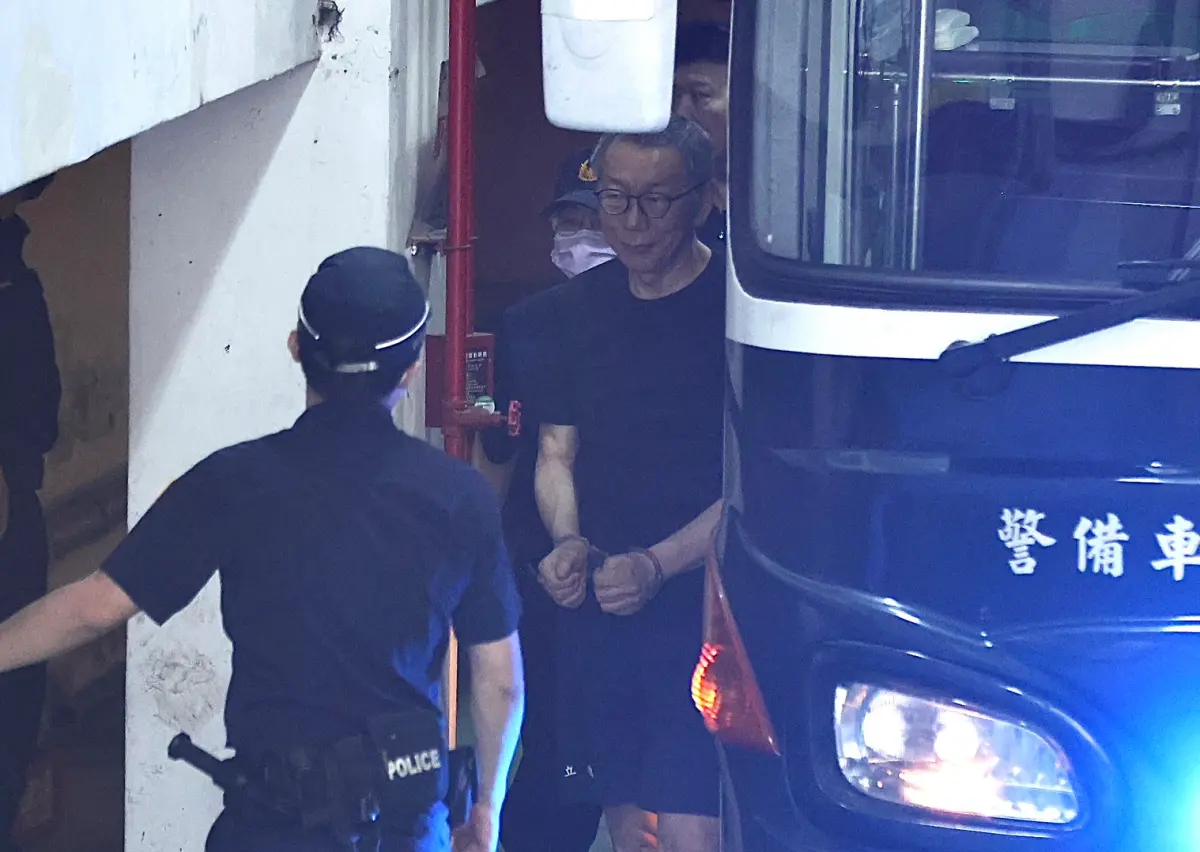 ▲柯文哲由法警押解時露出微笑。（圖／記者朱永強攝）