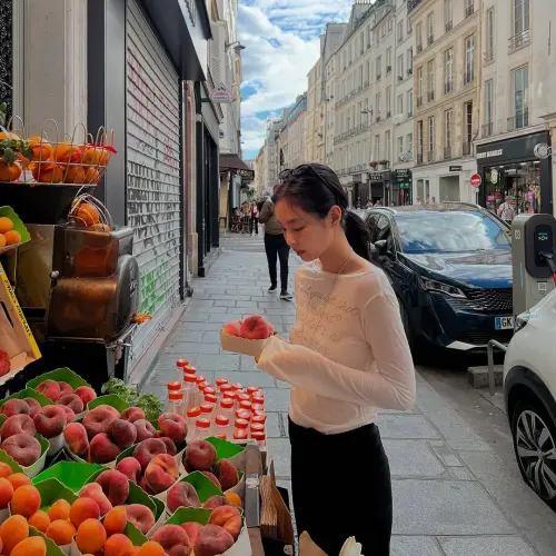 ▲Jennie臉上未抹胭脂，輕鬆遊走巴黎街頭、逛水果攤。（圖／Jennie IG @jennierubyjane）