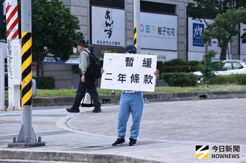 ▲民眾黨黨代表大會在桃園會展中心舉行，場外有小草高舉「暫緩二年條款」字牌。（圖／記者吳翊緁攝，2025.08.10）