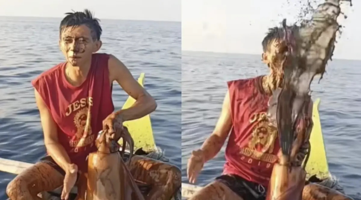 ▲菲律賓漁民開心向鏡頭展示捕獲的巨型魷魚，沒想到手中魷魚突然噴出一大股墨汁。（圖／翻攝自Facebook/Cris Anthony Rapsing Rio）