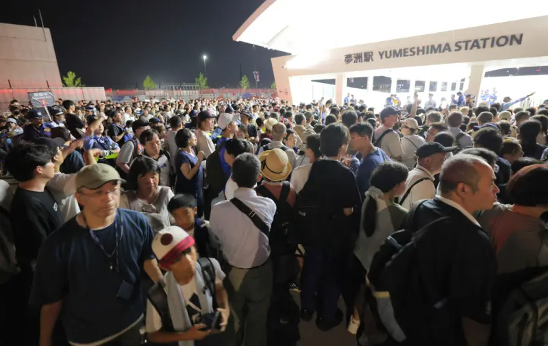 ▲日本大阪地鐵中央線13日晚間因停電停駛，夢洲站實施入場管制，導致許多參觀大阪世博的民眾回不了家。（圖／美聯社／達志影像）