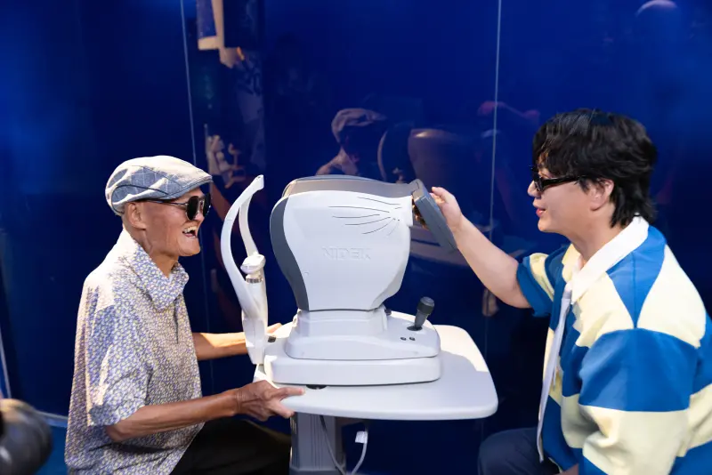 ▲金曲歌王蕭煌奇（右）2025年全新單曲〈輝煌旅行社〉於今（15）日發行，MV開場埋了地獄梗，由蕭煌奇幫李炳輝（左）量視力，帶聽眾看見他們腦海裡的奇幻旅行。（圖／華納音樂提供）