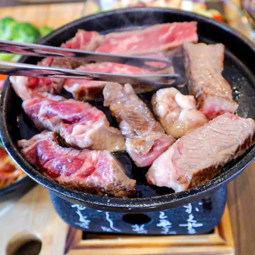 ▲肉排的熟度可由顧客自己於烤盤上炙烤，是餐點的一大特色。（圖／翻攝「烤舖.吧」臉書）