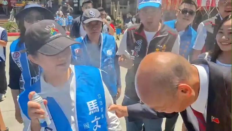 ▲韓國瑜抓著盧秀燕的手臂「討噴」，盧秀燕仔細地對著他的禿頭噴了一圈又一圈。（圖／讀者提供，2025.08.21）