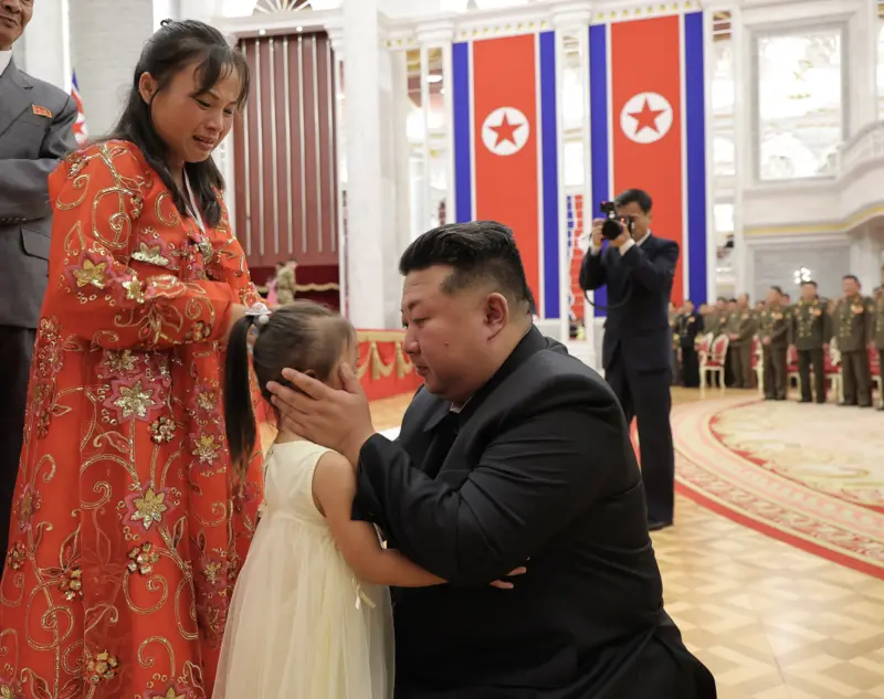    ▲北韓領導人金正恩日前出席赴俄烏前線作戰將士的授勳儀式，特別蹲下來擁抱陣亡將士的小孩，在他們耳邊叮囑。（圖／翻攝自朝中社）  