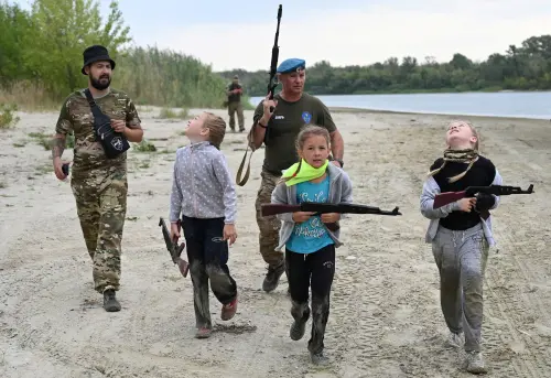 ▲俄羅斯舉行兒童軍事訓練營隊，教學童投擲手榴彈、揹槍枝行軍，參與者最小只有８歲。（圖／路透社／達志影像）