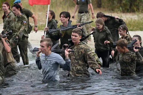 ▲俄羅斯舉行兒童軍事訓練營隊，教學童投擲手榴彈、揹槍枝行軍，參與者最小只有８歲。（圖／路透社／達志影像）