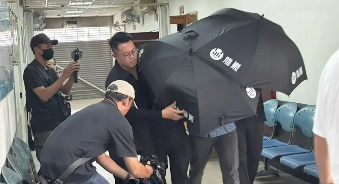 ▲羅男遭開16槍轟爛慘死，檢方解剖釐清死因，家屬到場認屍，請殯葬業者撐黑傘躲避媒體拍攝。（圖／翻攝畫面）