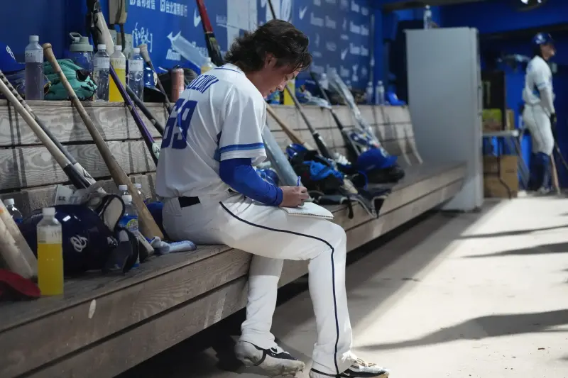 ▲富邦悍將日籍投手鈴木駿輔在換局時，會拿著筆記本紀錄下投完球的感受。（圖／富邦悍將提供）