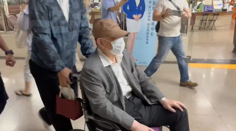 ▲威京集團主席沈慶京坐輪椅到台北地院出庭。（圖／翻攝畫面）