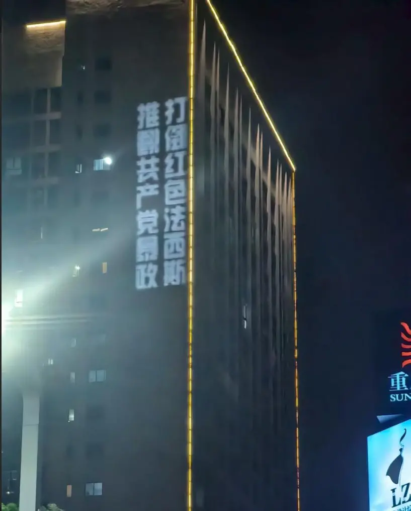 ▲中國重慶大學城傳出有不知名人士，在大樓外牆以投影打下：「打倒紅色法西斯，推翻共產黨暴政」等標語，引發譁然。（圖／翻攝自X平台）