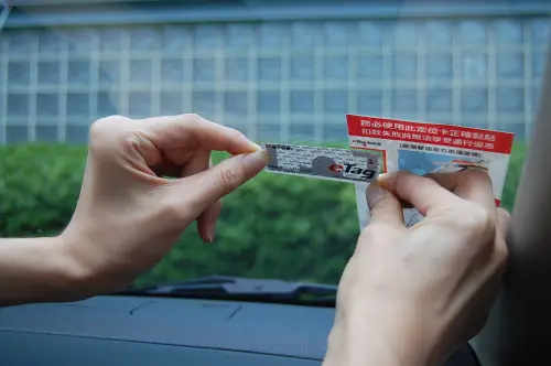 ▲遠通電收門市同仁黏貼eTag標籤於汽車擋風玻璃。（圖／遠通電收提供）