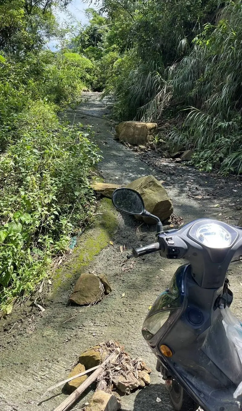 ▲山區農路經常只能騎機車到達,沿路還有落石,有時突然暴雨。(圖/古坑鄉公所提供,2025.09.03)