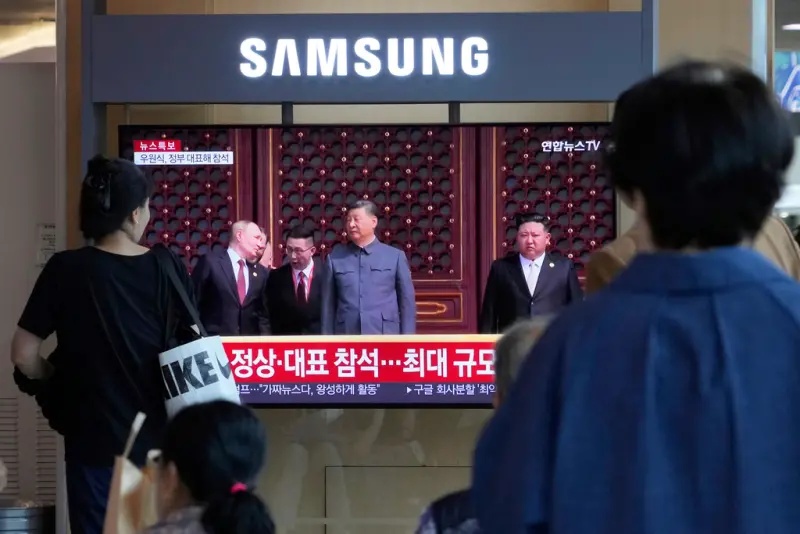 ▲中國3日舉行九三閱兵，韓國首爾火車站的新聞節目播出習近平、蒲亭、金正恩同台的畫面。（圖／美聯社／達志影像）