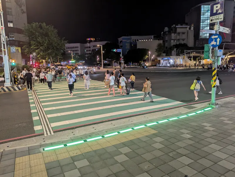 ▲新北市政府推出「行人地面警示燈」,率先在板橋府中捷運站試辦,以同步發光的LED地磚提醒行人和駕駛當前號誌燈態。(圖/新北市交通局提供)