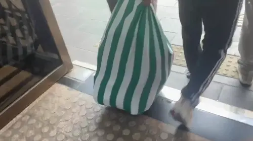 ▲民眾黨志工從台北地院側門拖著裝有柯文哲書本的布袋離去。（圖／翻攝畫面）