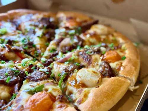 ▲必勝客「月見七盎司厚燒牛披薩」，每一片都有鮮嫩干貝＋月見切達白玉。（圖／記者蕭涵云攝）