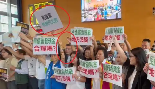 ▲藍綠為普發5萬爭議在中市議會吵嚷不休，江和樹卻舉著「民進黨放快柯文哲」手牌亂入（紅圈處）。（圖／記者顏幸如攝，2025.09.15）