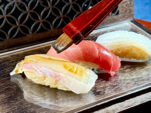 ▲第一回壽司「鮪魚中腹／花枝／真鯛」，讓饕客自刷壽司醬的嘗試，使人印象深刻。（圖／記者蕭涵云攝）