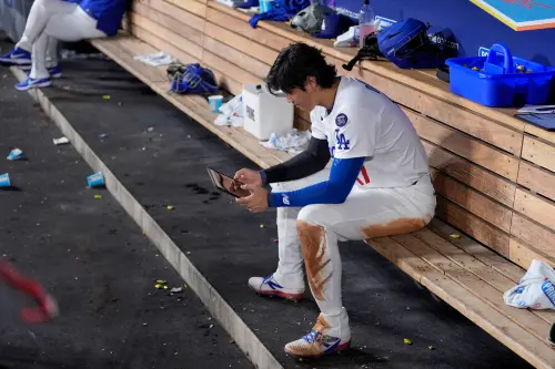 ▲賽後《美聯社》拍到大谷翔平坐在賽後凌亂、無人的休息區，透過平板查看資料，認真希望檢討、找出這場比賽可改進之處，讓人看到偉大球星對於勝負的執著。（圖／美聯社／達志影像）