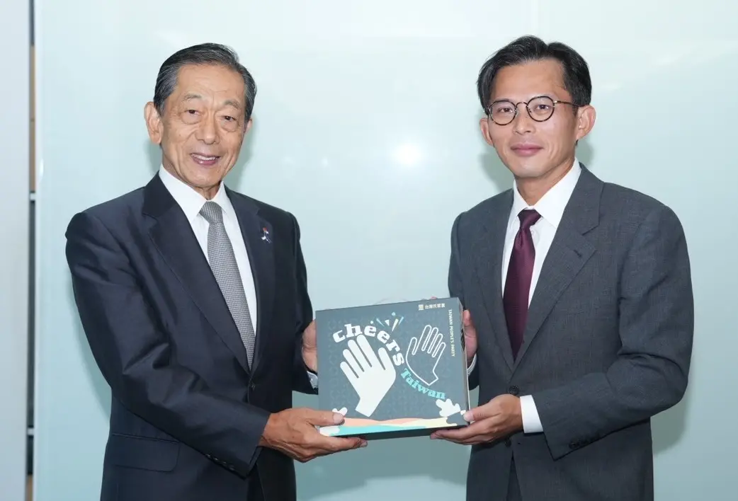 ▲日台交流協會會長隅修三（左）昨拜會台灣民眾黨，由黨主席黃國昌親自接待，致贈紀念啤酒禮盒。（圖／民眾黨提供）