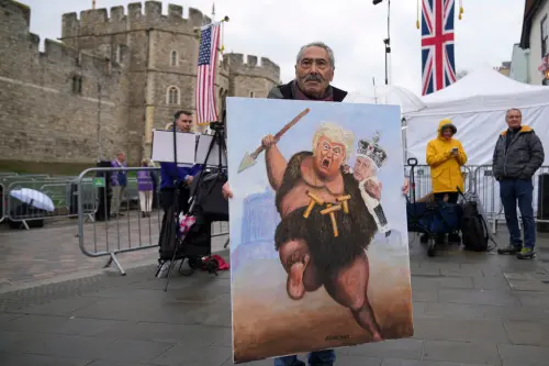▲溫莎城堡外有民眾舉海報諷刺川普與英國王室。（圖／美聯社／達志影像）