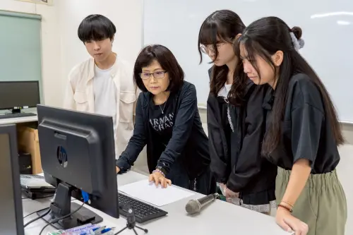 ▲修平科大數媒系參展學生，在老師馮文君提導下，於電腦前專注進行作品討論。（圖／修平科大提供）