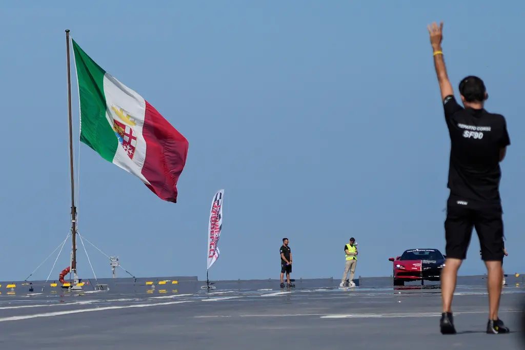 ▲義大利車手巴羅內（Fabio Barone）18日駕駛法拉利SF90跑車，在航空母艦的甲板上飆速，最終現場團隊宣布測得時速164公里，順利刷新最速「船上跑車」紀錄。（圖／美聯社／達志影像）