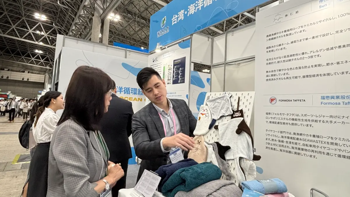 ▲伸仁紡織於參展現場向日本民眾介紹由廢棄漁網改質再造而成的海洋擦手巾。（圖／ 海洋委員會提供）
