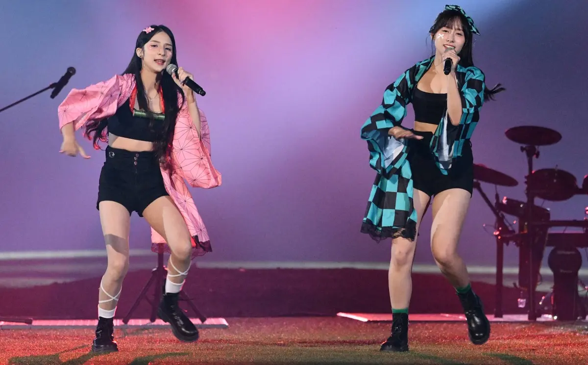 ▲富邦悍將Fubon Angels女孩「寵愛天使」主題日，潔潔、Kapo不僅穿上禰豆子、炭治郎服裝，唱跳搖滾版的鬼滅之刃主題曲《紅蓮華》，潔潔表演最後爬上3層樓高的桿頂「高空作業」，彷彿特技演出，引爆全場球迷歡呼，更有人直呼：「這表演太危險！」（圖／記者林柏年攝,2025.09.20）