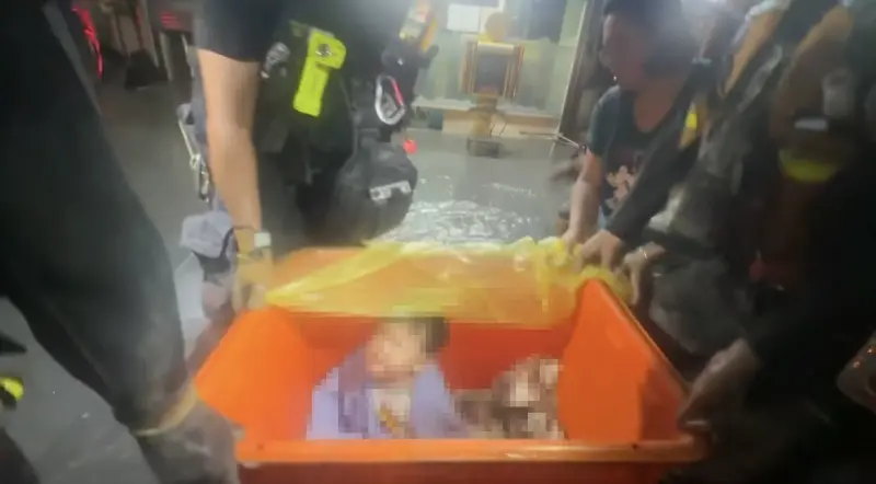▲洪水沖進花蓮光復釀災，23日深夜救難人員用橘色大桶子裝嬰兒、幼童協助脫困。（圖／翻攝Threads@jon73418）