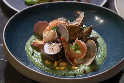 ▲「酒煮海鮮｜絲瓜菠菜醬｜藤椒油｜黑檸檬」將蛤蜊融合絲瓜，前菜就很有家常菜的影子。（圖／記者葉政勳攝）