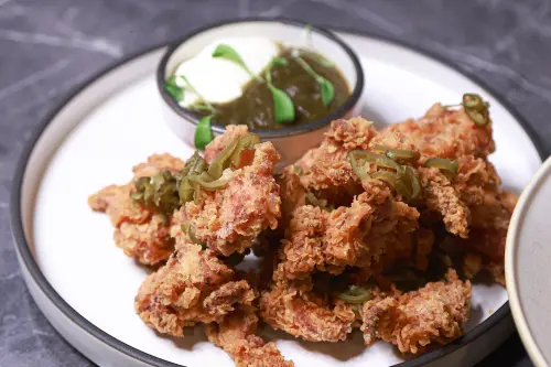 ▲「剝皮辣椒炸雞｜義式青醬｜香菜苗」是改良自剝皮辣椒雞湯的想法。（圖／記者葉政勳攝）