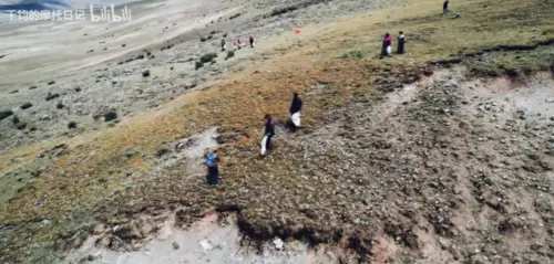 ▲中國自媒體博主22日到蔡國強、始祖鳥炸山的現場，發現有上百位藏族村民在撿垃圾，還有大型無人機運送垃圾下山。（圖／翻攝自B站／千鈞的摩托日記）