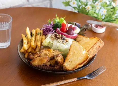 ▲迷迭香雞腿拼盤以獨家香料醃製的雞腿排搭配爽脆生菜，還有自家鮮奶吐司。（圖／嘉義市衛生局提供）