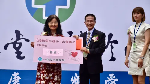 ▲七賢國小校長楊勝任（左）代表接下「一品堂中醫」捐助的善款。（圖／記者陳美嘉翻攝）