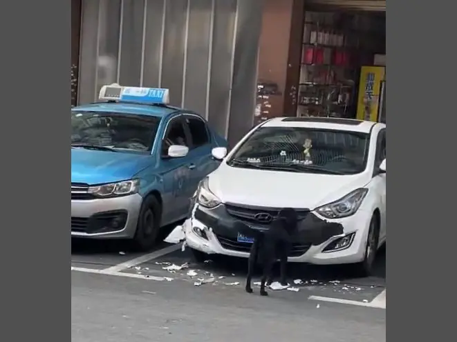 ▲中國湖南一位女車主，停在停車場內的車子竟然被一條黑狗盯上，對著車頭保險桿和外裝就是一頓猛啃，把車子外裝搞得稀碎，破壞力驚人。（圖／翻攝自微博）