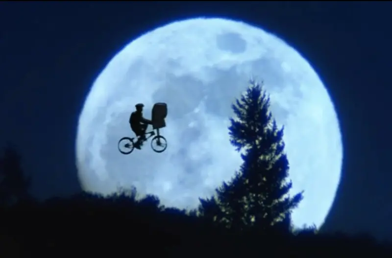 ▲中秋假期欣賞月亮電影超狂片單，包括史蒂芬史匹柏的賣座巨片《外星人》（如圖），腳踏車飛過月球表面已成影史經典畫面。其他還有《神偷奶爸》，主角異想天開要偷走月亮，日本片《竹取物語》竟出現古裝和服公主搭著歐美電影裡的飛碟離開地球的獵奇片段。（圖／摘自IMDb）