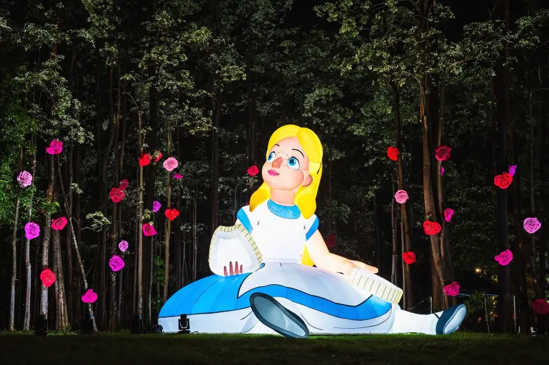 ▲「2025嘉義市光織影舞」今（4）日開跑至10月19日，而今年以《愛麗絲夢遊仙境》為主題，現場打造9米高的愛麗絲造型氣偶。（圖／嘉義市政府提供）