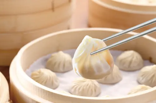 Chopsticks pinch a Xiao Long Bao. (Din Tai Fung)
