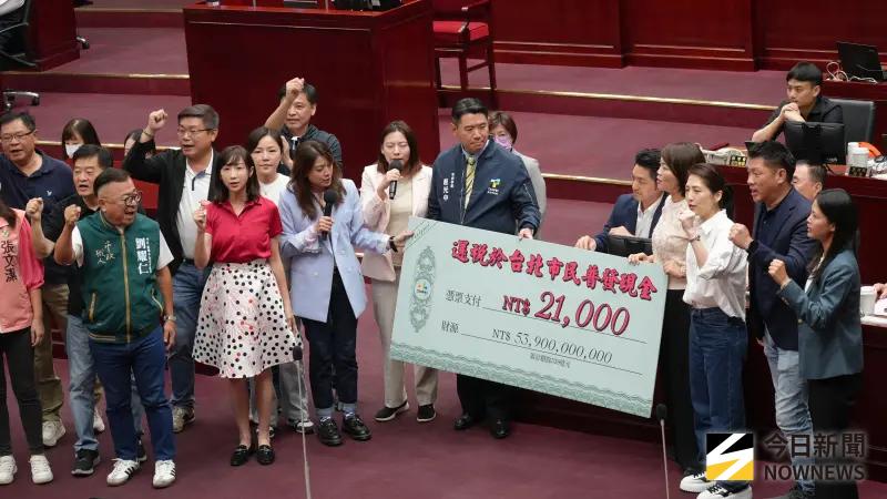   ▲北市議會開議，民進黨市議會黨團提案台北市民「普發現金2.1萬」，將大張支票送給市長蔣萬安。（圖／記者炯昌攝，2025.10.09）  