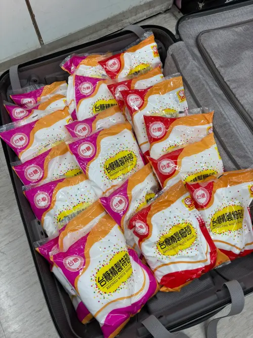 ▲蘋果糖專賣店老闆池田喬俊，將重達20公斤的台灣砂糖塞入行李箱內，準備帶回日本使用。（圖／X@池田喬俊）