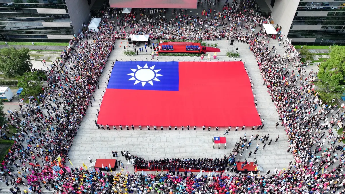 ▲76位民防義警及霹靂小組聯手展護全國最大長36公尺，寬24公尺的巨幅國旗進場(圖／市政府提供2025.10.10)