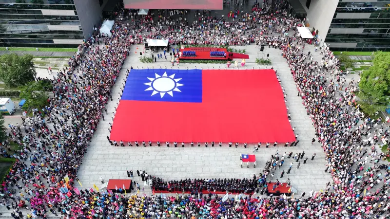 ▲76位民防義警及霹靂小組聯手展護全國最大長36公尺，寬24公尺的巨幅國旗進場(圖／市政府提供2025.10.10)