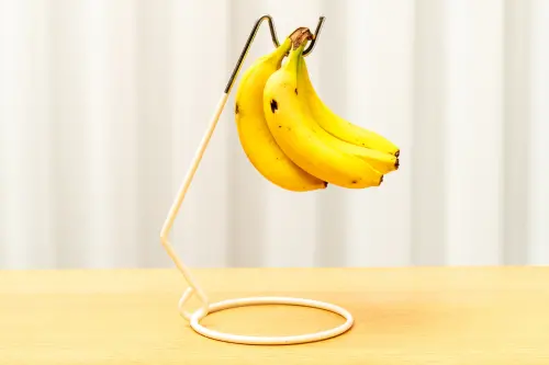 ▲日本專家認為，把香蕉吊起來或倒著放，減少其與桌面等任何表面接觸的面積，能讓香蕉保存得更久。（圖／取自photoAC）