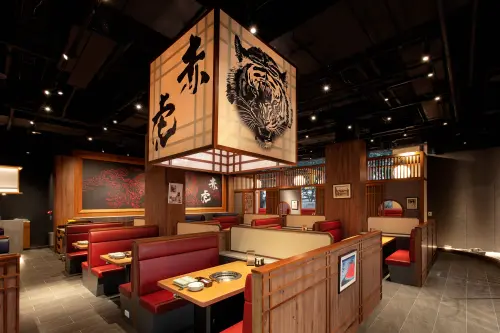 ▲赤虎新莊店保留一貫的紅色系沉穩風格，入口處融入日式枯山水意境的花蓮奇石、燈龍與枯木造景，更凸顯日系血統。（圖／赤虎提供）