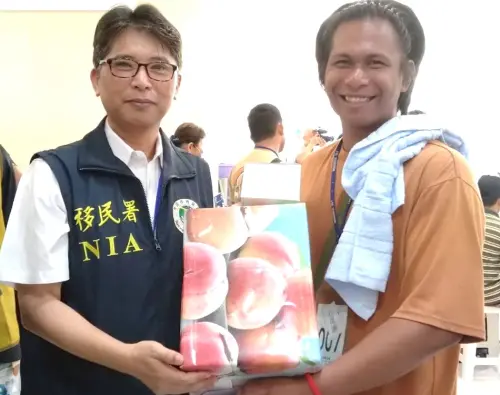 ▲在義診及義剪活動中也進行有獎徵答，由國境事務大隊專門委員蔡英傑(左)頒獎給獲獎的漁工。(圖／移民署高雄港隊提供)