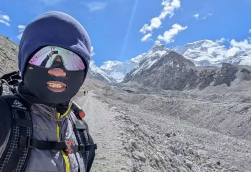 ▲攀登途中天氣放晴，呂忠翰在卓奧友山區營地前露出笑容，背後雪線清晰，象徵漫長等待後迎來的天氣窗與希望。（圖／橘子關懷基金會提供）